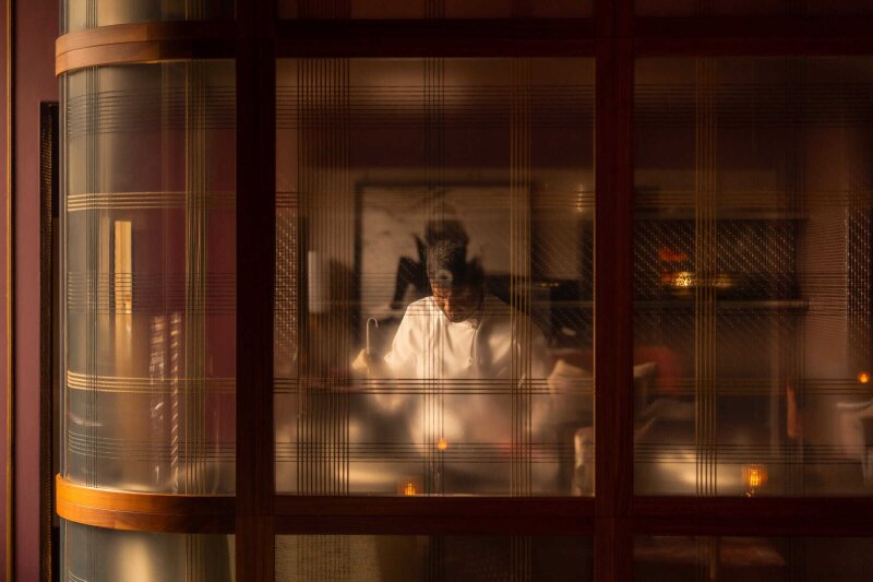 Chef in reflection of glass.