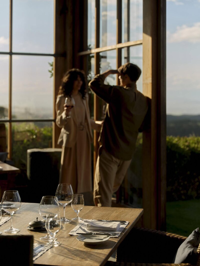 Two people having drinks next to a dinner table.